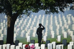 With artillery smoke hanging in the air from a 21-gun salute by his company at Fort Leavenworth, the 500th Military Police Detachment, Army Sgt. Travis Smith saluted during the playing of "Taps," during Monday's Memorial Day ceremony at Fort Leavenworth National Cemetery. DAVID EULITT/The Kansas City Star