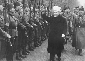 Der Großmufti von Jerusalem [Amin al Husseini] bei den bosnischen Freiwilligen der Waffen-SS. Der Großmufti ist auf dem Truppenübungsplatz ein[getroffen] und schreitet die Front der angetretenen Freiwilligen mit erhobenem Arm ab.