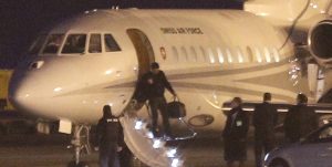 An unidentified man leaves a Dassault Falcon jet of Swiss air force at the airport in Geneva, Switzerland, Sunday, Jan 17, 2016. A US government plane waited nearby to bring back to the US the men who were left from imprisonment in Iran the day before. (AP Photo/Laurent Cipriani)