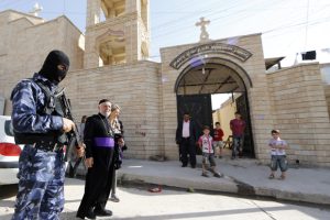 An Iraqi security officer, stands guard outside the Church of the Virgin Mary in the northern town of Bartala, on June 15, 2012, east of the northern city of Mosul as some Iraqi security stayed in the town to protect the local churches and community. The exiled governor of Mosul, Iraq's second city which was seized by Islamist fighters last week, has called for US and Turkish air strikes against the militants. AFP PHOTO/KARIM SAHIB (Photo credit should read KARIM SAHIB/AFP/Getty Images)